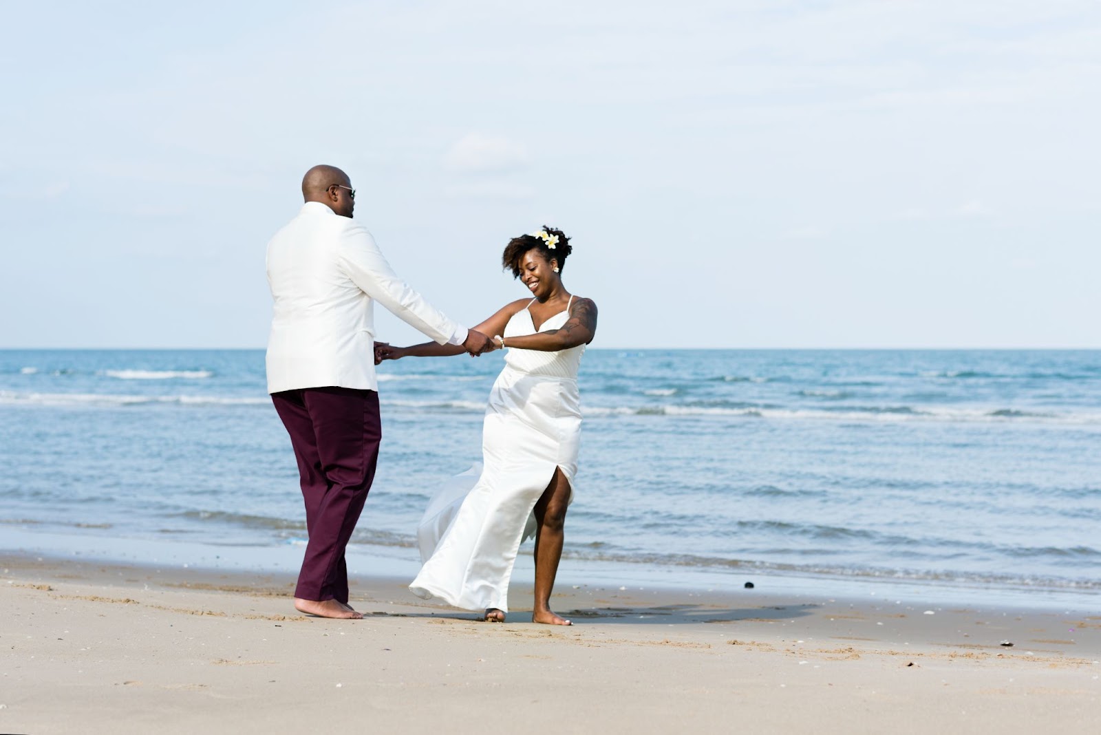African-American couple dancing joyfully on a beach after winning through wedding competitions — a celebration of love, freedom, and magical dream weddings.