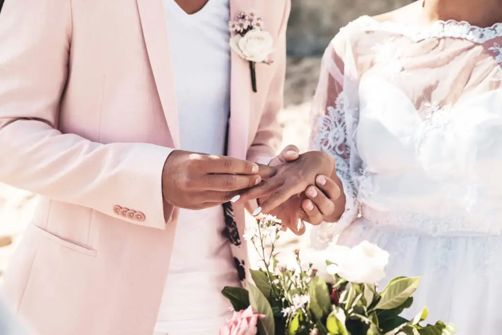 A couple exchanging rings at their beach wedding. One of many dream moments made possible through UK wedding raffle competitions