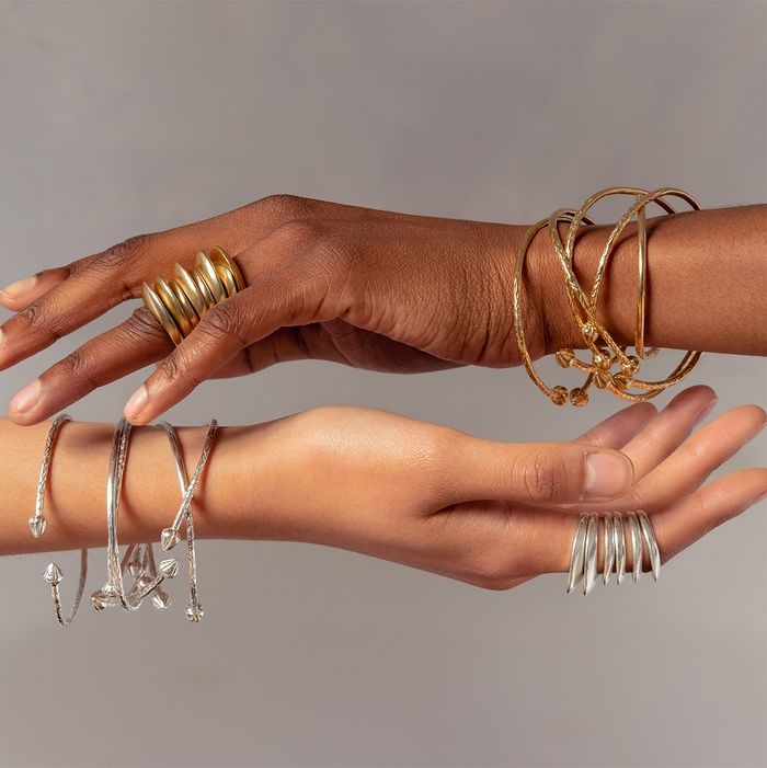 Ethical wedding planning jewellery inspiration featuring fair-trade African metals in gold and silver rings and bracelets on diverse hands.