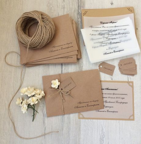 Go green with your invitations through ethical wedding planning using sustainable kraft paper wedding invitations, natural twine, eco-friendly tags, and dried flowers on rustic wood
