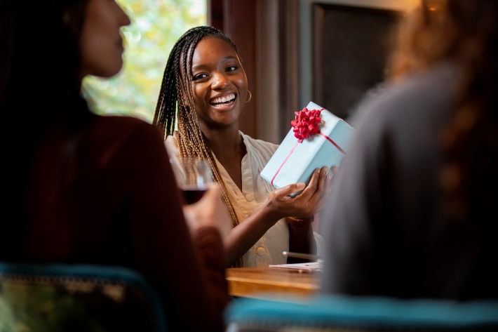A smiling woman receiving a wedding guest gift, highlighting the appreciation for attendees.