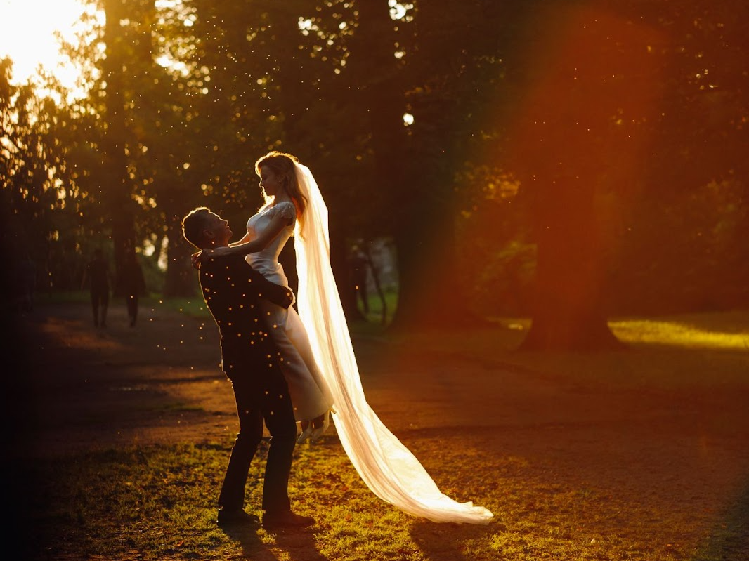 wedding couple under a perfect timed sunset beam of light creating a beautiful image-A wedding photography tip