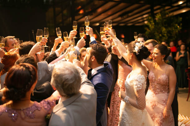 Wedding guests raising champagne glasses in a toast, celebrating in an atmosphere that truly helps personalise your wedding.