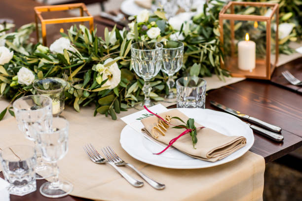 An elegantly set wedding table with floral garlands and a candle, showcasing decor details that personalise your wedding.