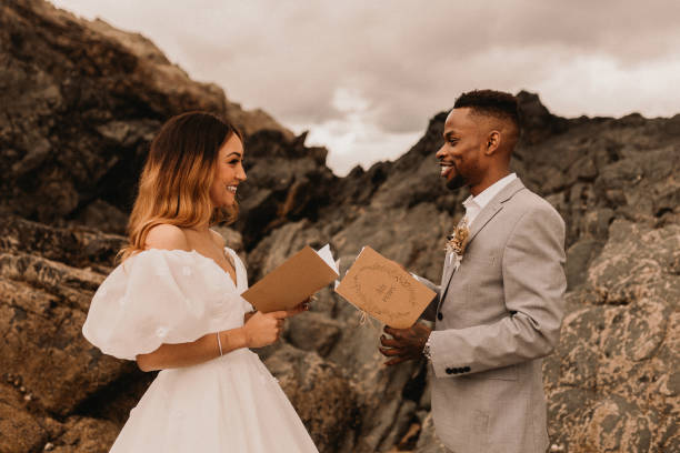 A couple exchanging vows on a rocky beach, a heartfelt moment that helps personalise your wedding ceremony.